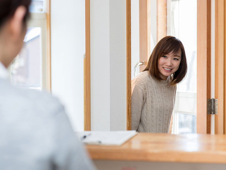 ドアを開け来店する女性