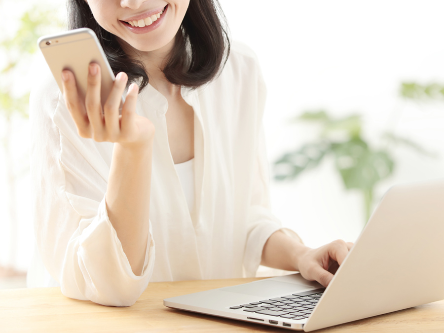 スマートフォンとパソコンでwebページを見る女性